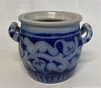 Front view of the small stoneware crock showing the hand-painted blue floral design.