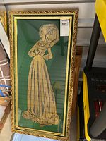 Full view of framed medieval brass rubbing of Margaret Francis 1484, showing green velvet background and gold ornate frame.