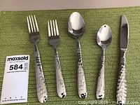 Full set of five flatware pieces showing bowl and handle details with hammered texture.