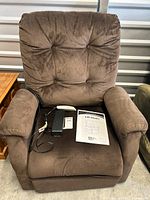 Front view of brown Mega Motion power lift recliner with accessories on seat