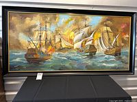 Framed oil painting depicting naval battle with ships on ocean, signed by M. Vasquez
