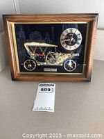 Frontal view of framed vintage clock showing the 1910 Rolls Royce car model and clock dial with faux wood frame.