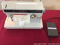 Kenmore sewing machine on red tablecloth with foot pedal attached via cord