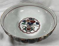 Wide angle view showing scalloped edges and gold trim around bowl rim