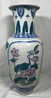 Front view of tall porcelain vase with lotus and bird hand-painted design