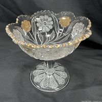 Front and side view showing scalloped rim, hand painted bronze and clear flowers, clear pressed glass, and textured footed base.