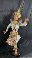 Full view of the vintage resin Thai dancer doll standing on a base, showing costume, pose, and overall condition.