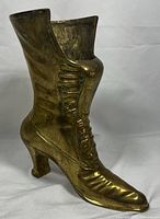 Front and side view of the Victorian style brass boot showing detailed laces and heel.
