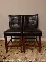 Front view of two brown faux leather pub chairs placed side by side.