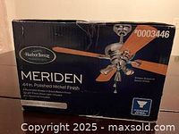 Close-up photo of Harbor Breeze Meriden 44-inch polished nickel ceiling fan box showing branding and fan image.