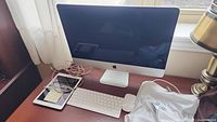 Desk setup showing iMac, Magic Keyboard, Magic Mouse, iPad and cables