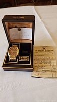 Bulova watch in original box with included receipt showing handwritten details at side.