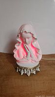 Same Madonna Mother Mary lamp lit, glowing red inside highlighting facial details and veil folds.
