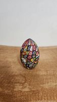 Front view of the vintage Murano art glass egg paperweight, showing colorful millefiori designs.