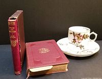 Overview of two early maroon leatherette books and one floral tea cup with saucer