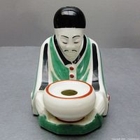 Front view of ceramic Asian elder perfume burner figurine on gray surface with visible bob bowl