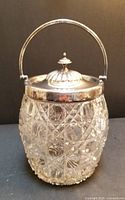 Front view of the antique pressed glass cookie jar showing the cane pattern and silver lid with handle.