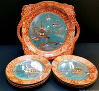 Front view of cake plate with six small plates stacked in front