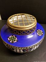 Top view of brass lattice arranger grid and cobalt blue enamel surface with geometric motifs