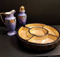 Shows 9" lacquered wooden box with 5 cream-colored ceramic condiment dishes in a circular arrangement and the 6.5" purple cream and sugar set with a floral band in front