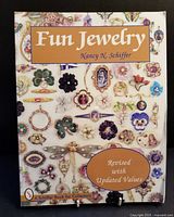 Front cover of a softbound reference book 'Fun Jewelry' by Nancy N. Schiffer showing images of vintage costume jewelry pieces with a label indicating revision with updated values.