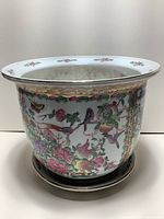 Front view showing the rounded shape and detailed hand-painted exotic birds, butterflies, and flowers