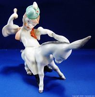 Front left view showing boy with green hat raising stick, sitting on donkey with raised tail