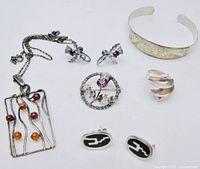 Overview shot showing all six items: ring, cuff bracelet, pendant necklace, Scottish brooch with matching earrings, and separate pair of earrings.