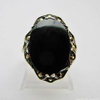 Front view of the sterling silver ring showing large shiny oval black centerpiece and marcasite accents around the bezel.
