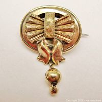 Front view showing oval frame, fanned bow motif and hanging bead dangle