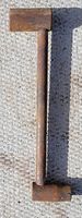 Top side view of antique rusty tomahawk wrench with a rusty rectangular socket head.