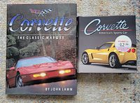 Photo showing two Corvette hardcover books side by side on a carpet background. One titled 'Corvette The Classic Marque' by John Lamm, the other titled 'Corvette America's Sports Car' with a yellow Corvette on the cover.