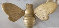 Close-up of large gold resin queen bee showing detailed wings and segmented body