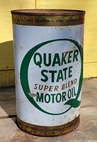 Front of vintage Quaker State motor oil tin showing logo and product name with rust on top and bottom edges.