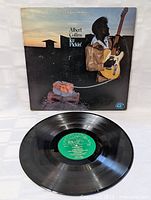 Front view of Albert Collins Ice Pickin album cover and vinyl record with visible green label on the record showing album details.