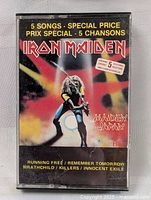 Front cover of Iron Maiden Maiden Japan cassette tape showing artwork and track listing.
