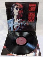 Original John Lennon Live in New York City vinyl LP on Capitol Records with black vinyl and maroon label, and album cover featuring John Lennon with guitar and sunglasses.