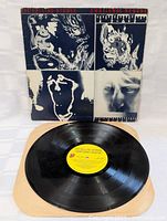 Vinyl record on a tan paper inner sleeve with yellow center label showing album title and band name.