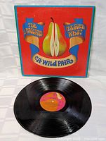 Front cover of A Wild Pair LP showing artwork of a sliced pear and band names The Staccatos and The Guess Who.