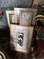 Group photo of several framed farm animal prints stacked and leaning against furniture, showing various sizes and styles