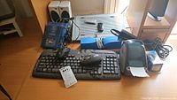 Photo showing Logitek keyboard and wireless mouse, disk reader, Targus laptop chill pad, AudioWorks speakers on desk