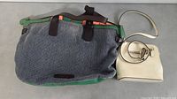 Two purses side by side showing colors and design - large blue and green tote and small off-white handbag