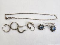 925 silver jewelry including three pairs of earrings and one chain bracelet.