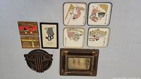 Overview of nine artwork items including Chinese art plaques, caricature drawing, wooden plaques, round plaque, and framed ship painting.