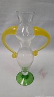 Full front view of the Fenix Lady Vase showing clear body with yellow handles and green base.