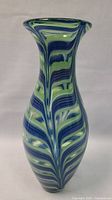 Side view of the vase showing the blue, green, and white swirl pattern and the flared rim.