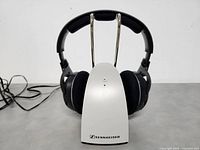 Front view of Sennheiser wireless headphones mounted on charging/base station showing overall condition and design.