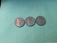 Front sides of three Canadian 1 dollar coins from 1968, 1971, and 1972 showing Queen Elizabeth II.