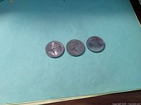 Obverse side of the three Canadian 1 dollar coins showing Queen Elizabeth II's portrait.