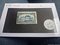 Blue Canadian postage stamp featuring Champlain's Home in Quebec, centered on a black background card labeled with Scott #99 and lot number.